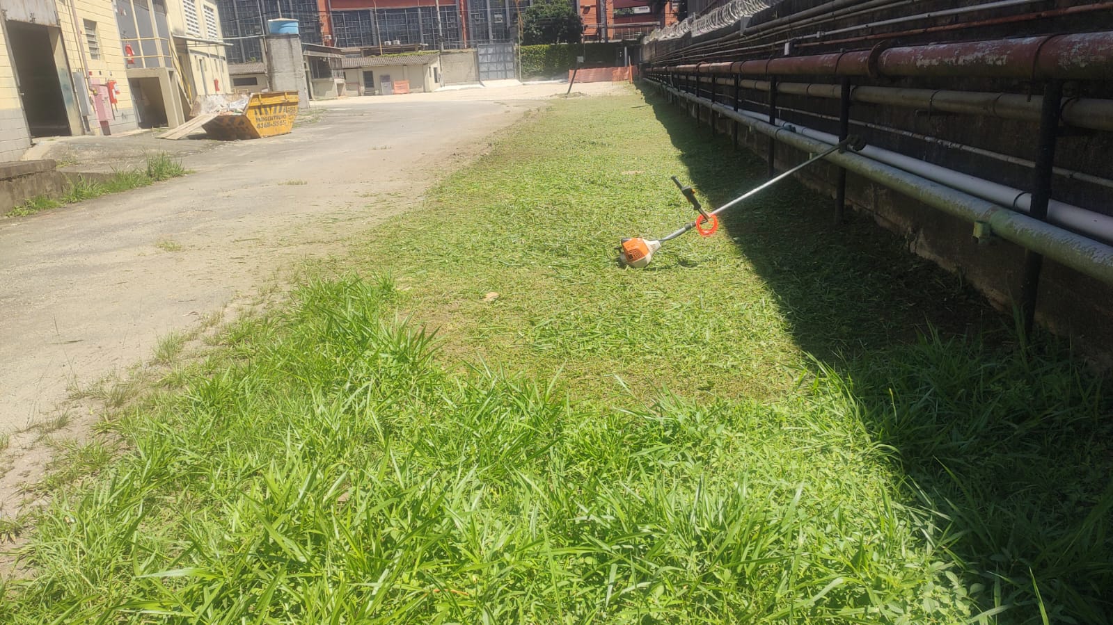 Roçadeira em operação em área industrial